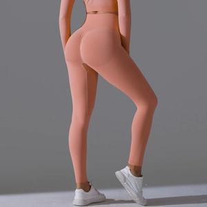 Detail of high waist seamless peach lifting leggings in orange-pink with scrunch butt design