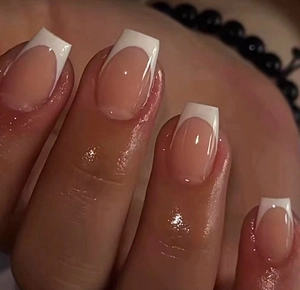 Macro detail of classic French manicure press-on nails with white tips and glossy finish