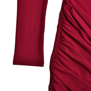 Détail de la manchette rouge foncé et de la texture élégante du tissu drapé plissé