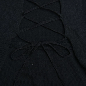 Gros plan détaillé du laçage croisé au dos et du nœud sur une robe en maille noire