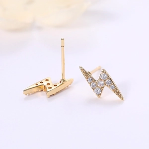Detailed macro view of gold lightning bolt earrings with cubic zirconia pave stones