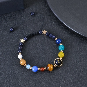 Macro shot of solar system beads bracelet with blue sandstone and golden star charms