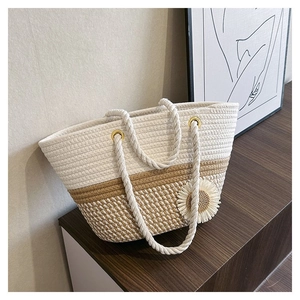 Detail of woven tote bag featuring sunflower decor and rustic cotton rope handles
