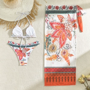 Detailed flat lay of a floral 3-piece bikini set with a matching tropical print sarong wrap