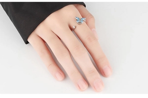 Close-up of silver snowflake spinner ring with blue butterfly and crystal on finger