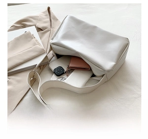 Detail showing internal capacity of large white soft leather tote with daily essentials