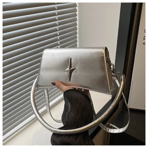 Détail d'un sac à main argenté métallisé avec pendentif étoile 3D et poignée rigide