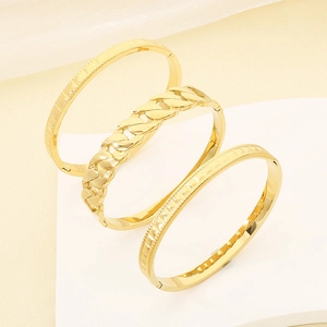 Set of three luxury gold-toned bangles with curb chain and geometric patterns