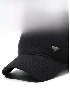 Detailed view of the black knitted baseball cap showing the ribbed texture and stiff brim