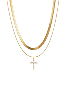 Close-up of gold double layer necklace with snake chain and diamond cross pendant