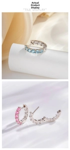 Détail de boucles d'oreilles créoles argentées avec zircons bleu ciel et dégradé rose