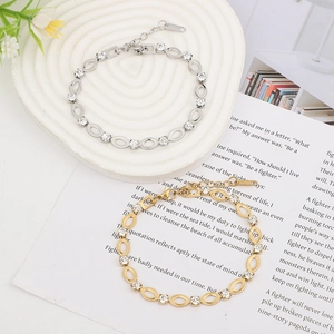 Detail of gold and silver stainless steel bracelets with crystals on ceramic tray