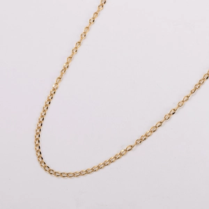 Close-up of golden curb chain necklace with polished metallic texture on white background