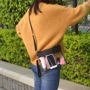 Clear PVC crossbody stadium bag with adjustable black strap shown being worn by a model