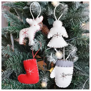 Detail of felt Christmas ornaments with snowflake embroidery hanging on a festive tree