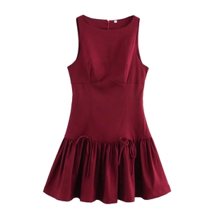 Detail of burgundy sleeveless dress with pleated skirt and elegant waist ribbon tie