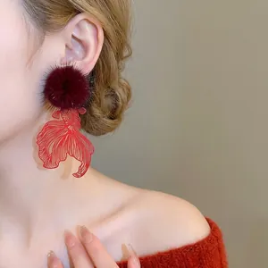 Elegant red hollow carp fish earrings with plush pompom pendants for winter fashion