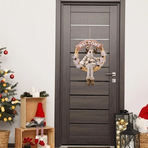 Detail of Christmas wreath with plush reindeer and Welcome banner on a wooden door