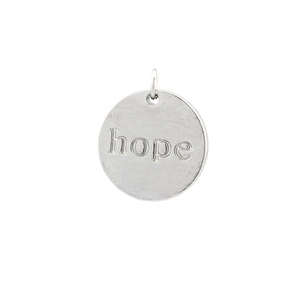 Close-up of a silver circular pendant engraved with hope and a hollow star detail