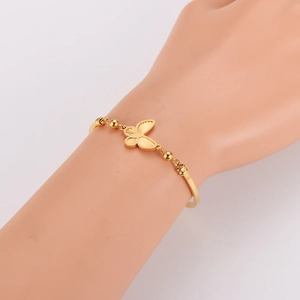 Gold butterfly bracelet for women with minimalist beads and metallic finish on wrist