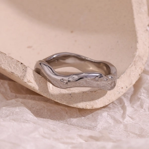 Detailed view of silver stainless steel ring with hammered texture and wavy design