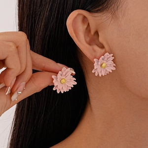 Detail of pink floral stud earrings with gold stamen on a model for a sweet look