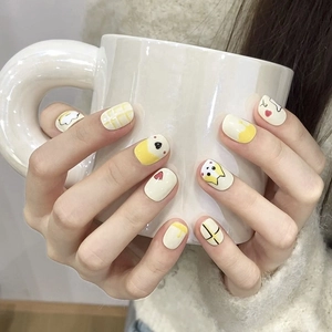 Faux ongles courts avec chiens jaunes peints à la main et motifs à carreaux crème
