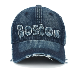 Detail von BOSTON-Patch auf abgenutzter dunkelblauer Denim-Baseballkappe mit Fransen