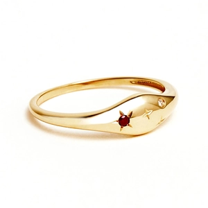 Close-up of gold-plated S925 sterling silver ring with star engraving and red gemstone