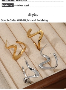Macro detail of wave spiral earrings in polished gold and silver stainless steel