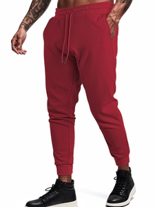 Close-up of red waffle knit fabric texture on men's jogger pants with drawstring