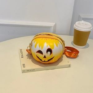 Detail view of yellow pumpkin crossbody bag with wide strap on a magazine with coffee