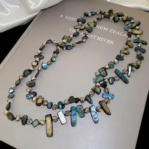 Irregular shell and crystal beaded necklace with colorful shimmer on a vintage book