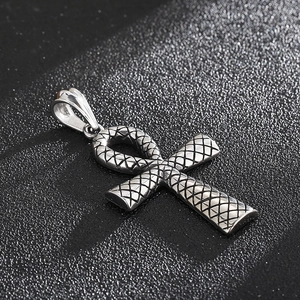 Gros plan sur un pendentif Ankh argenté vintage avec texture d'écailles de serpent