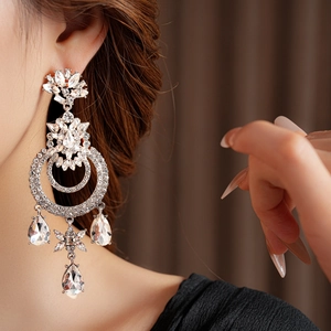 Vue détaillée de boucles d'oreilles pendantes en cristal argenté portées par un mannequin
