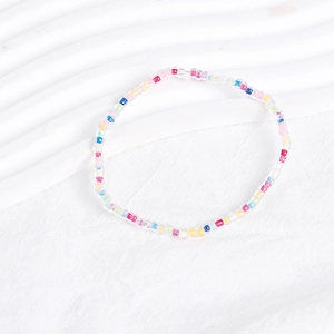 Detailed flat lay of vibrant Bohemian mixed color bead bracelets on white wavy background