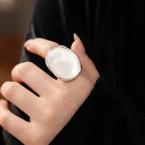 Minimalist oval resin ring set with large white stone in liquid silver metal setting