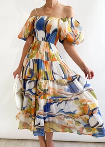 Detail of off-shoulder puff sleeve dress with colorful abstract print and tiered skirt