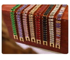 Detailed view of colorful rectangular zircon bracelets on a professional wooden stand