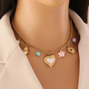 Collier en chaîne dorée avec cœur turquoise, fleur rose et pendentifs cœur en perle sur mannequin