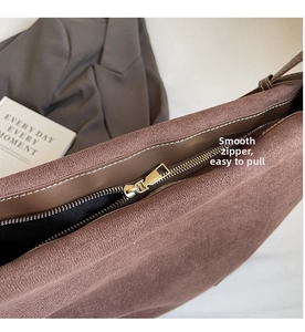 Detail of a brown matte tote bag with a smooth golden metal zipper and dark fabric lining