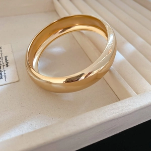 Vue détaillée du large bracelet jonc plaqué or avec finition miroir poli en boîte cadeau