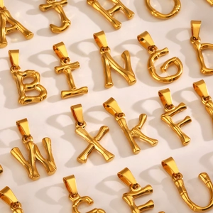 Bamboo style gold plated stainless steel alphabet pendants in a neat array display