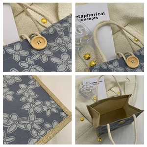 Detail showing the floral canvas fabric texture, wooden button closure, and rope handle