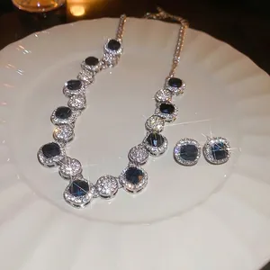 Geometric square blue gemstone jewelry set with necklace and earrings on white plate