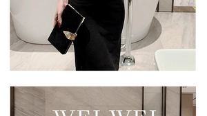 Detail of elegant black velvet clutch bag with golden leaf clasp in a luxury setting