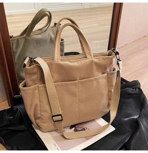 Detail of khaki corduroy tote bag texture with adjustable strap and front pocket detail
