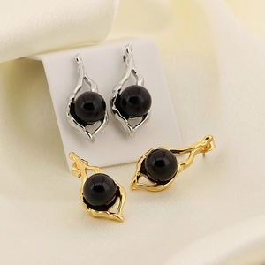 Detail view of French vintage geometric earrings in gold and silver with black beads