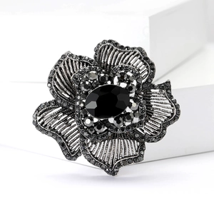 Detail of vintage flower brooch with black oval gemstone and micro-pave crystals