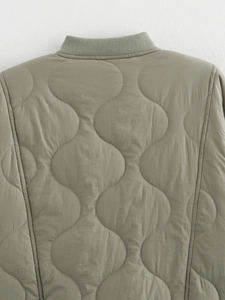 Detail of sage green quilted jacket featuring a distinct onion pattern and ribbed collar